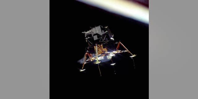 The Apollo 11 Eagle lunar module, in a landing configuration, photographed in lunar orbit from the Columbia Command and Service Module.