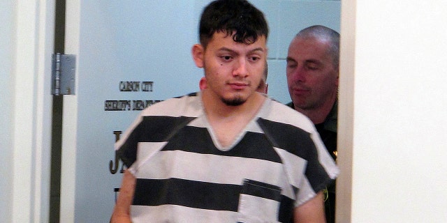FILE - In this Jan. 24, 2019 file photo, Wilber Ernesto Martinez-Guzman, 19, of El Salvador, is escorted into the courtroom for his initial appearance in Carson City Justice Court in Carson City, Nev.