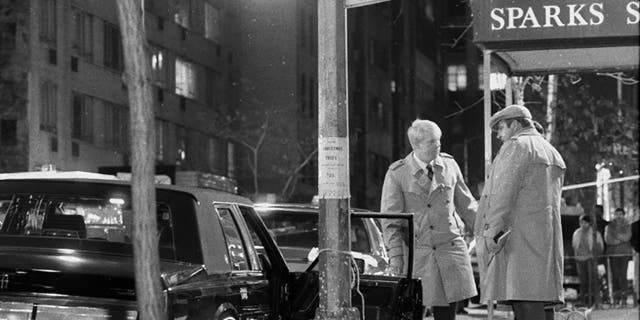 Detectives stand over body of reputed mob boss Paul Castellano, after execution on 46th St. Body of Castellano's chauffeur, Thomas Bilotti, lies partially covered in the street, far left. (Photo By: Tom Monaster/NY Daily News via Getty Images)