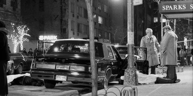 Detectives monitor the body of renowned crowd leader Paul Castellano after he was executed outside the Sparks Steakhouse on 46th Street in December 1985. The body of Thomas Castellano's driver, Thomas Bilotti, partially rests in the street, on the far left. (Photo by: Tom Monaster / NY Daily News via Getty Images)