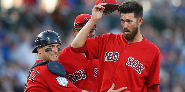 Boston Red Sox catcher Christian Vazquez, left, calls for someone to come and check out starting pitcher Rick Porcello, right, after Porcello was knocked over by a batted ball during the second inning of a spring training baseball game against the Chicago Cubs on Monday in Mesa, Ariz.