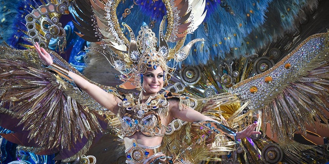 TOPSHOT - A nominee for queen performs during the main stage of the Carnival of Santa Cruz in Santa Cruz de Tenerife on the Spanish Canary island of Tenerife, on February 07, 2018. The costumes are more than five meters high and over 80 kilos in weight. The event began on January 12 and finishes on February 18 with orchestras playing Caribbean and Brazilian rhythms throughout the festivities that range from elections for the Carnival Queen, the Junior Queen and the Senior Queen, to children and adult murgas (satirical street bands), comparsas (dance groups) and street performances. / AFP PHOTO / DESIREE MARTIN (Photo credit should read DESIREE MARTIN/AFP/Getty Images)