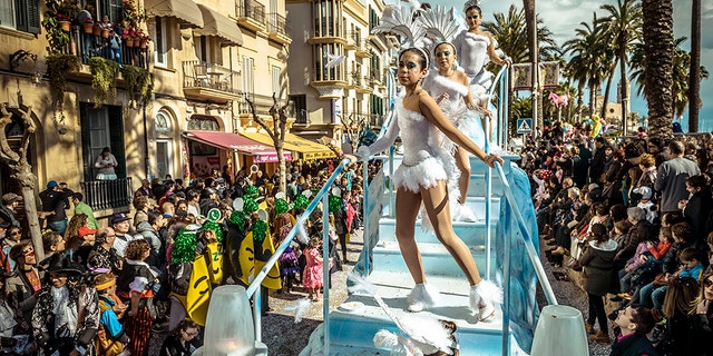 Revelers in their colorful costumes dance on their float during the children carnival parade in Sitges. (Photo by Matthias Oesterle/Corbis via Getty Images)