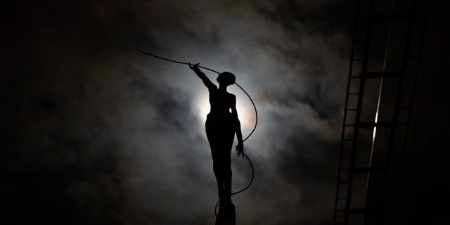 A sculpture is silhouetted against a full moon in Brussels, Wednesday, March 20, 2019. (AP Photo/Francisco Seco)