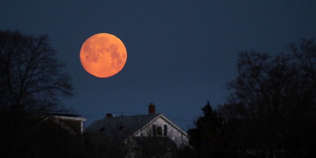 The moon sets on the Dorchester district in Boston early in the morning of March 20, 2019.