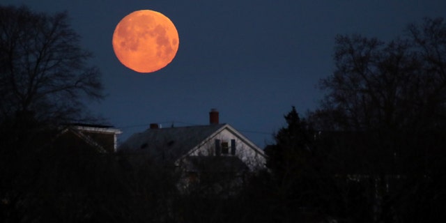 The moon sets on the Dorchester district in Boston early in the morning of March 20, 2019.