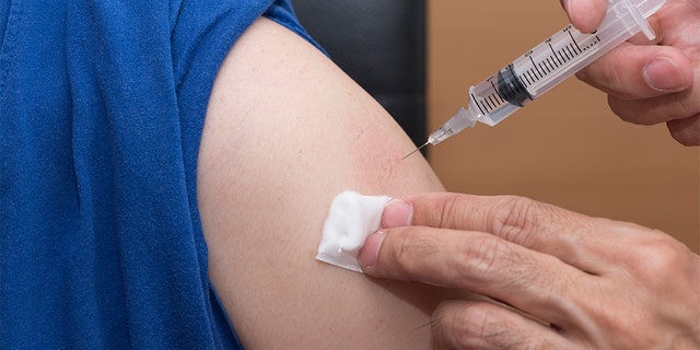 Doctor giving an injection into the patient arm