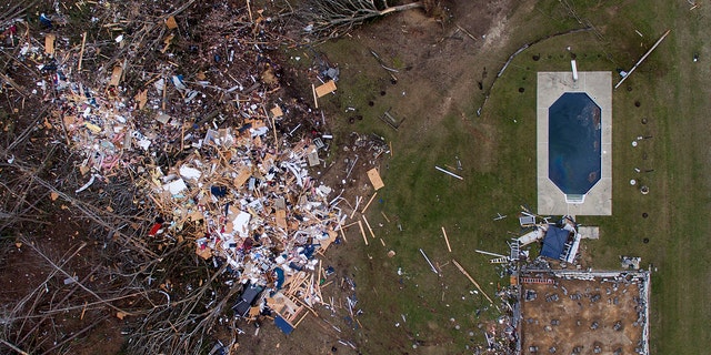 Debris from a home litters a yard the day after a tornado blew it off its foundation, lower right, in Beauregard, Ala., Monday, March 4, 2019.