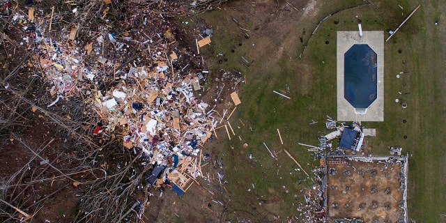 Debris from a home litters a yard the day after a tornado blew it off its foundation, lower right, in Beauregard, Ala., Monday, March 4, 2019.
