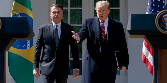 President Donald Trump and Brazilian President Jair Bolsonaro arrive for a news conference in the Rose Garden of the White House, Tuesday, March 19, 2019, in Washington. (AP Photo/Evan Vucci)