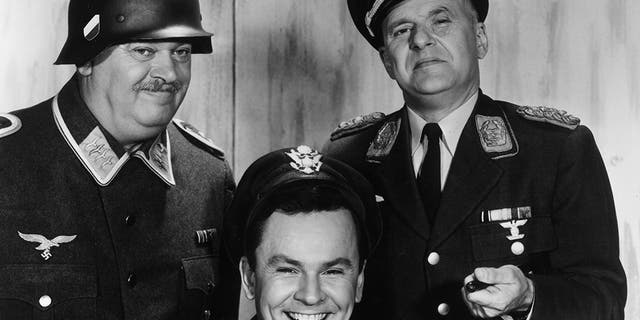 1965: L-R: Austrian actor John Banner, American actor Bob Crane, and German-born actor Werner Klemperer pose together in a promotional portrait for the World War II-set television series, 'Hogan's Heroes'. Banner and Klemperer wear Nazi uniforms, and Crane wears a cap and jacket. (Photo by CBS Photo Archive/Getty Images)