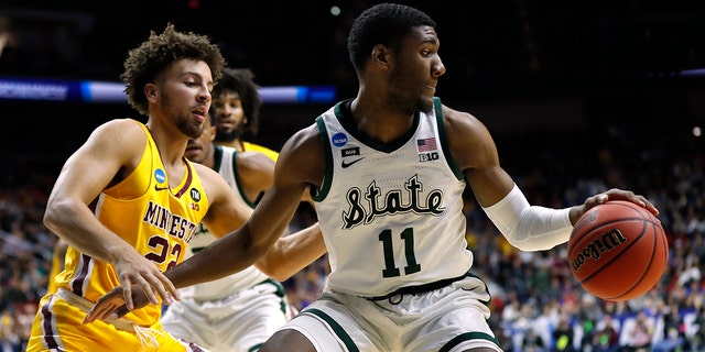 Michigan State forward Aaron Henry (11) drives around Minnesota guard Gabe Kalscheur. (Associated Press)