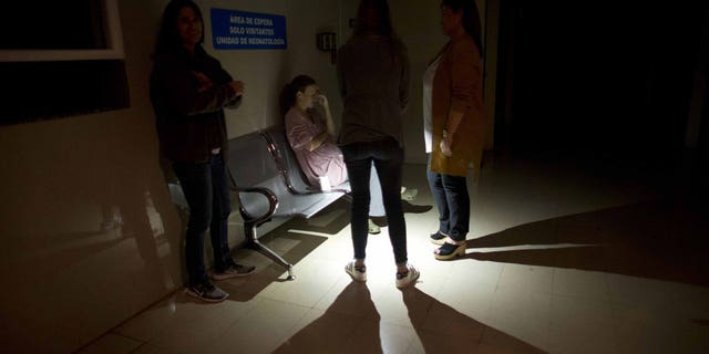 Mothers and relatives wait outside of an intensive care room for babies at a clinic, during a power outage in Caracas, Venezuela, Thursday, March 7, 2019. A power outage left much of Venezuela in the dark early Thursday evening in what appeared to be one of the largest blackouts yet in a country where power failures have become increasingly common.