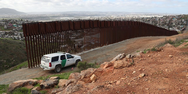 A U.S. Border Patrol vehicle stands at the U.S. and Mexico border fence near Tijuana, Mexico.