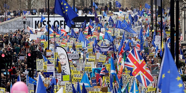 Demonstrators carry posters and flags during a Peoples Vote anti-Brexit march in London, Saturday. 