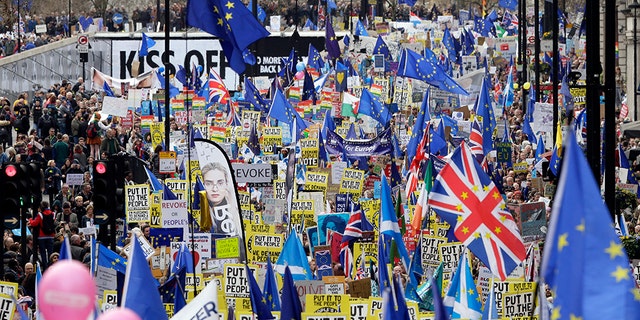 Demonstrators carry posters and flags during a Peoples Vote anti-Brexit march in London, Saturday.