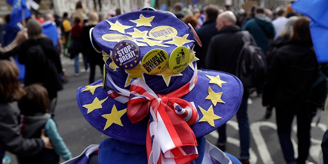 A demonstrator wears a hat decorated with the EU and British colors during a Peoples Vote anti-Brexit march in London, Saturday. 