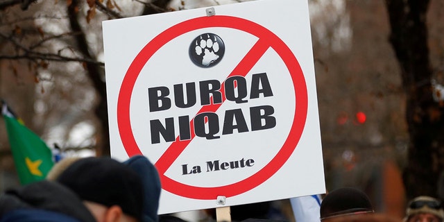 A sign opposing religious attire is displayed during protests by groups La Meute and Storm Alliance in Quebec City, Quebec, Canada November 25, 2017. REUTERS/Mathieu Belanger