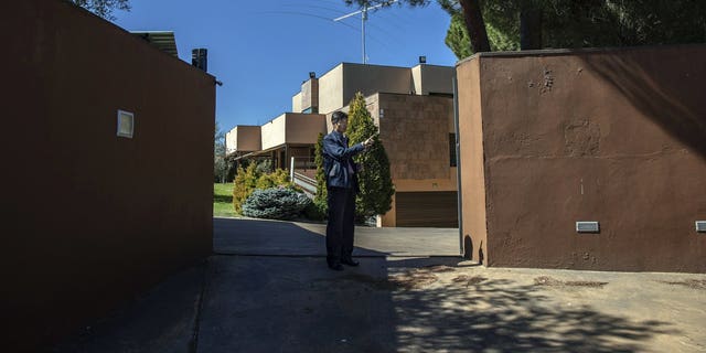 In this Wednesday, March 13, 2019 photo, a member of the North Korea's embassy tells reporters not to take pictures of the diplomatic building in Madrid, Spain. A Spanish court is accusing an American, Mexican and South Korean part of a 10-strong group that led an attack on the North Korean Embassy in February, saying the FBI was offered stolen data. 