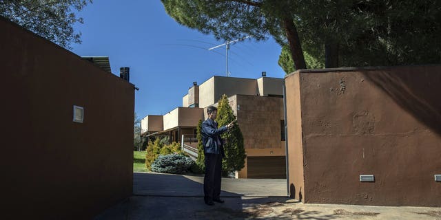 In this Wednesday, March 13, 2019 photo, a member of the North Korea's embassy tells reporters not to take pictures of the diplomatic building in Madrid, Spain. A Spanish court is accusing an American, Mexican and South Korean part of a 10-strong group that led an attack on the North Korean Embassy in February, saying the FBI was offered stolen data.