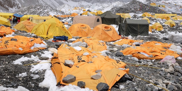 In this photograph taken on April 26, 2015, rocks are kept over flattened tents at Everest Base Camp, to cover the bodies of some of the people that died a day earlier as an earthquake triggered avalanche crashed through parts of the base camp killing scores of people.