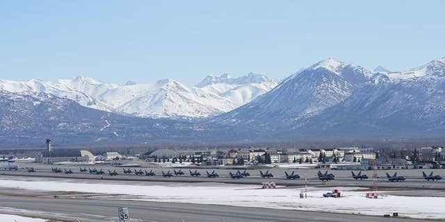 24 F-22 Raptors, a C-17 Globemaster III and an E-3 Sentry gathered on the Joint Base Elmendorf-Richardson flight line.