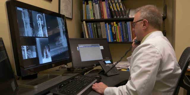 Dr. Sauerwine Scott examines X-rays of the Peruvian mummy.