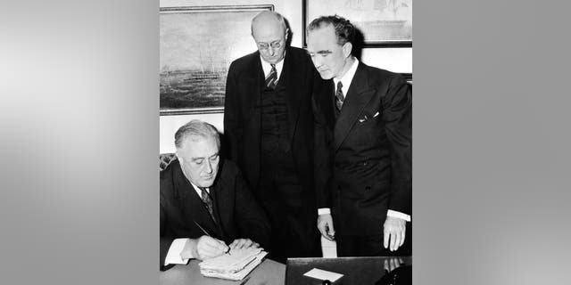 FILE - In this Jan. 2, 1939, file photo, the old family Bible Frank Murphy used in taking his oath of office in the president's study in the White House is autographed by President Franklin Roosevelt immediately after ceremony. Watching are Homer Cummings, center, retiring attorney general, and Murphy, right, the new attorney general. Presidents have a long history of signing Bibles, though earlier presidents typically signed them as gifts to send with a spiritual message. (AP Photo, File)