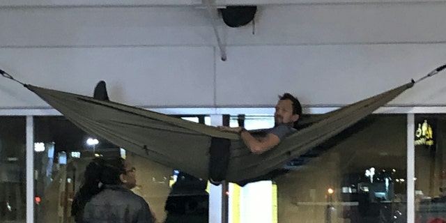 The traveler was spotted snoozing in his "genius" setup on Sunday morning.