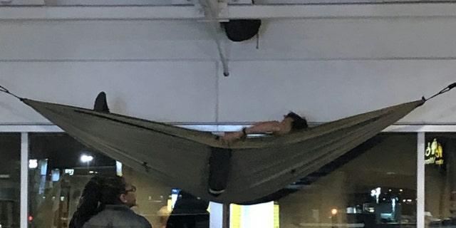 The man was eventually approached by an airport staffer, who presumably asked him to come down.