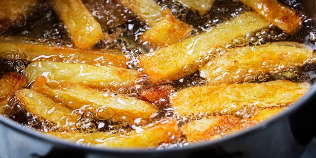 French fries in boiling oil in a pan