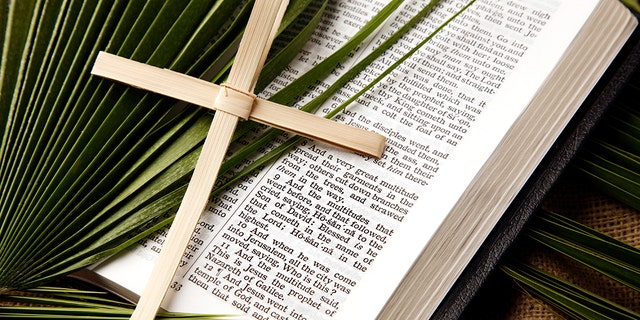 A Bible is shown as well as a cross made out of palm strands, plus a palm leaf. Religious elders during the time of Jesus were "concerned about the reaction of the Roman authorities who occupied the Holy Land at the time."