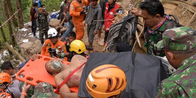 Rescuers carry a survivor of a collapsed mine on a stretcher in Bolaang Mongondow, North Sulawesi, Indonesia, on Thursday.