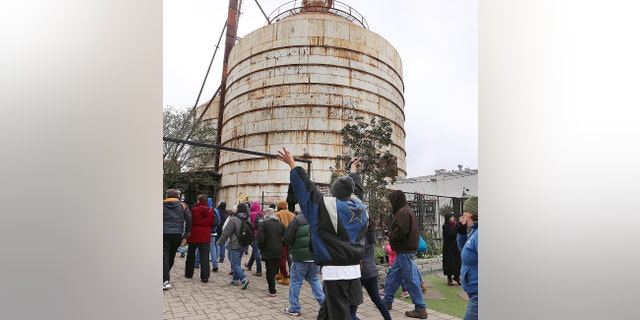 Church Under the Bridge members raise their arms while arriving at the new location at Magnolia Silos, Sunday, March 3, 2019, in Waco, Texas. The group had been meeting under the overpass at Interstate 35 but upcoming construction projects forced them to find the new location. Chip and Joanna Gaines offered them a temporary location at the Magnolia Market at the Silos.