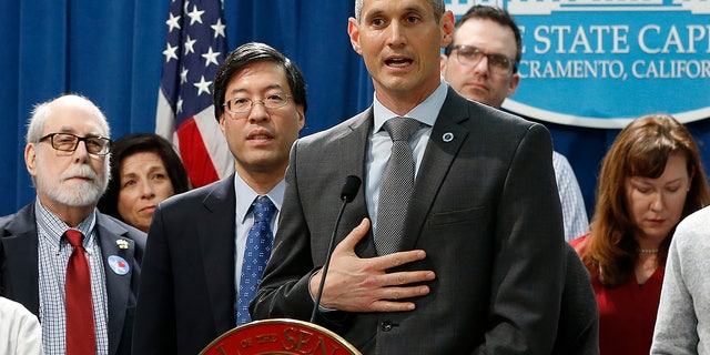 Dr. Eric Ball, center, representing the American Academy of Pediatrics in California, speaks in support of a proposed measure to have public health officials grant medical exemptions for vaccination instead of leaving the power to physicians, during a news conference in Sacramento, Calif.