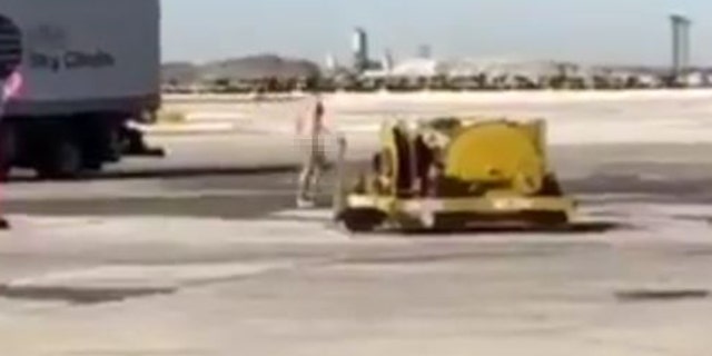 The man was filmed walking on the tarmac not wearing clothes.