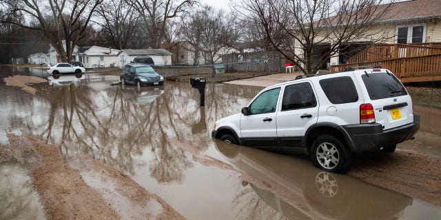 Cars are stuck in floodwaters Tuesday, March 19, 2019, in Fremont, Neb.