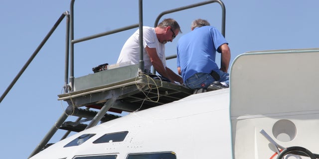 From left, Northrop Grumman technicians Joe McKee and Al Fournier work to repair aerial refueling equipment atop the T-3 test bed version of the E-8C Joint STARS aircraft during Bold Quest at Nellis Air Force Base, Nev., last month. (U.S. Air Force photo)