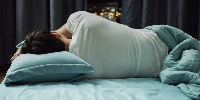 pria tidur miring di tempat tidur