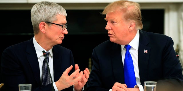 File photo: President Donald Trump talks to Apple Inc. CEO Tim Cook during the American Workforce Policy Advisory Board's first meeting in the State Dining Room of the White House in Washington, Wednesday, March 6, 2019. (AP Photo/Manuel Balce Ceneta)