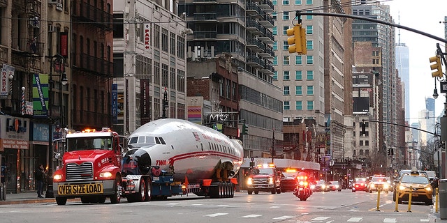 NEW YORK, NY - MARCH 23: The fuselage of a Trans World Airlines airplane is transported up 6th Avenue on March 23, 2019, in New York City. The jet was taken to Times Square and will end up at the new TWA Hotel at JFK airport.