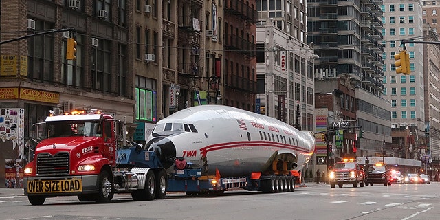 NEW YORK, NY - MARCH 23: The fuselage of a Trans World Airlines airplane is transported up 6th Avenue on March 23, 2019, in New York City. The jet was taken to Times Square and will end up at the new TWA Hotel at JFK airport.