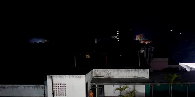 A man stands outside his home during a power outage in Caracas, Venezuela, Monday, March 25, 2019. A new power outage spread across much of Venezuela on Monday, knocking communications offline and stirring fears of a repeat of the chaos almost two weeks ago during the nation's largest-ever blackout.