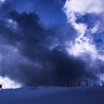 A man walks with his dog in front of a cloudy sky in the Thuringian Forest near Oberhof, Germany, March 12, 2019. 