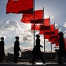 Bus ushers walk past red flags on Tiananmen Square during a plenary session of the Chinese People's Political Consultative Conference at the Great Hall of the People in Beijing, March 11, 2019. 