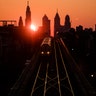 A train heads west as the sun rises from behind the city skyline in Philadelphia, March 6, 2019. 