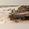 A man stands on the edge of a collapsed bridge in Chimanimani, about 600 kilometers southeast of Harare, Zimbabwe, March 18, 2019.