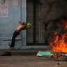 A demonstrator gets caught in a strand of barbed wire during clashes with the Bolivarian National Guard in Urena, Venezuela, Feb. 23, 2019. 