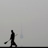 A worker is silhouetted as the cityscape is covered with a thick haze of fine dust particles, at the National Museum of Korea in Seoul, South Korea, March 12, 2019. 