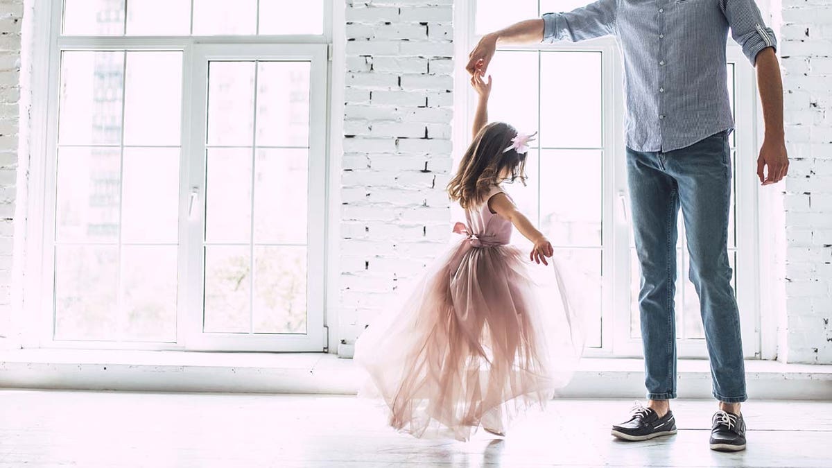 father twirls girl on the dance floor